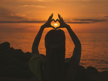 Heart hands at sunset