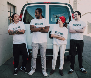 4 Volunteers standing next to a van